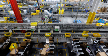 Nadzor nad Amazon skladištem s brojevima žutih robotskih nosača paketa između redova police