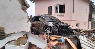 Razvalina kuće sa slamljenim vozilom u ruševinama nakon eksplozije