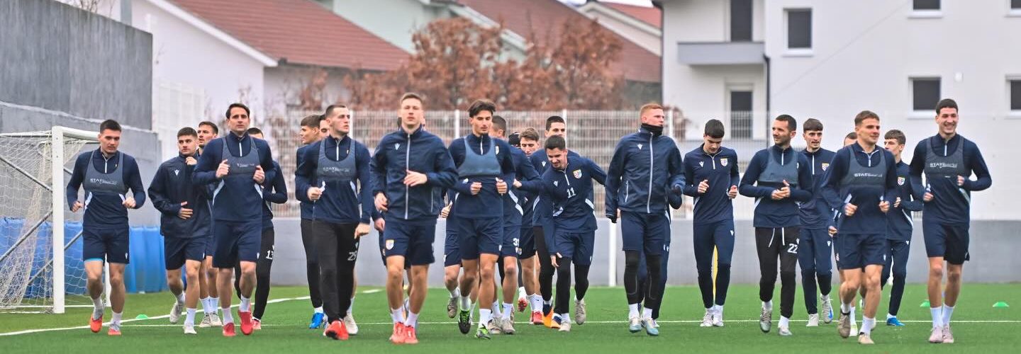 Fudbalski tim u plavim dresovima skupljen na terenu prije utakmice