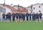 Fudbalski tim u plavim dresovima skupljen na terenu prije utakmice