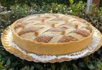 Zlatnasto-smeđa torta s ornamentalnom pletenom dekoracijom od tijesta na zlatnom tanjuru