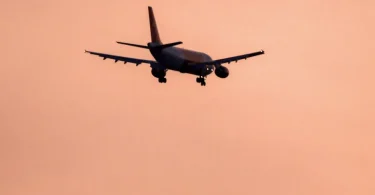 Silhueta putničkog aviona u letu protiv rozičastog neba tokom zalaska sunca