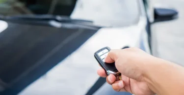 Ruka drži automobilski ključ s gumbom i