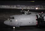 Vojni transportni avion Kraljevskog zračnog stvarstva s vojnicima na asfaltu durante noći