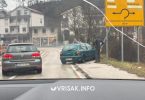 Oštećeni Fiat na cesti pored ograde, znak za sklizak kolnik na prometnoj nesreći