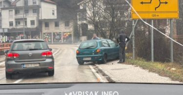 Oštećeni Fiat na cesti pored ograde, znak za sklizak kolnik na prometnoj nesreći