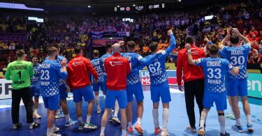 Hrvatska rukometna reprezentacija u plavim dresovima pjeva na terenu tijekom utakmice