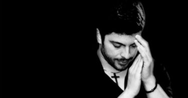 Portret muškarca s rukom blizu lica, crno-bijela fotografija