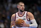 NBA igrač u bijeloj dresnoj Philladelphije s košarkaskom loptom
