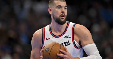 NBA igrač u bijeloj dresnoj Philladelphije s košarkaskom loptom