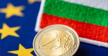 Eurokovanica od dva eura ispred zastave Evropske unije i Bugarske