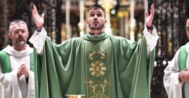 Svećenik u zelenoj liturgijskoj odjeći s podignutim rukama tijekom mise