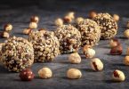 Homemade čokoladne kuglice s lješnjacima i zrnima žitarica na tamnoj površini