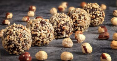 Homemade čokoladne kuglice s lješnjacima i zrnima žitarica na tamnoj površini