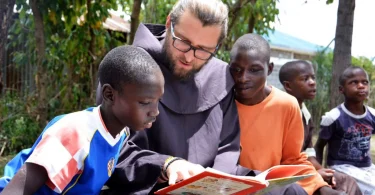 Franjevac Fra Miro Babić čita knjiga s afričkom djecom tijekom svoje humanitarne misije