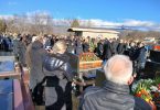 Okupljeni građani na sprovodu s cvijećem i vjerskim simbolima