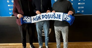 Tri osobe drže šal Grasshoppera na press konferenciji