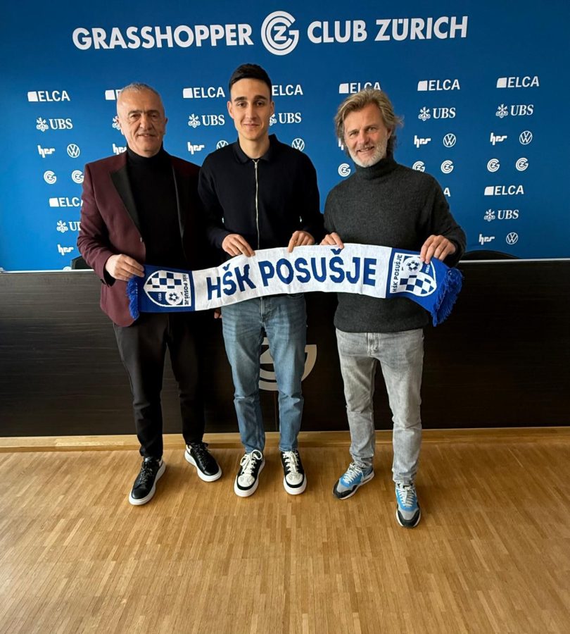 Tri osobe drže šal Grasshoppera na press konferenciji