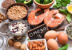 Zdravstvena hrana s omega-3: losos, jaja, bademi, sjemenke lana i orasi na sivoj površini