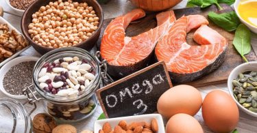 Zdravstvena hrana s omega-3: losos, jaja, bademi, sjemenke lana i orasi na sivoj površini