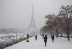 Parizani hodaju kroz Tuileries vrt prekrit snijegom s Eiffelovom kulom u pozadini