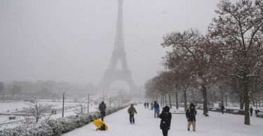 Parizani hodaju kroz Tuileries vrt prekrit snijegom s Eiffelovom kulom u pozadini