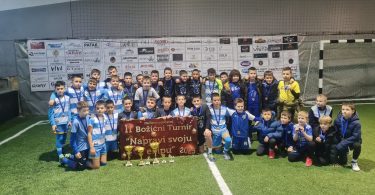 Dječji nogometaši u plavim i žutim dresovima s trofejom nakon završetka turnira