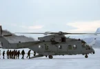 Vojni transport helikopter na snijegu sa vojnicima u Arktičkom području