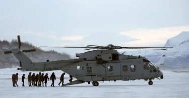 Vojni transport helikopter na snijegu sa vojnicima u Arktičkom području