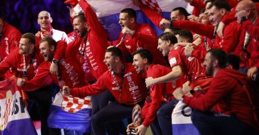 Članovi hrvatske rukometne reprezentacije u crvenim dresima sa bronzanom medaljom i zastavom