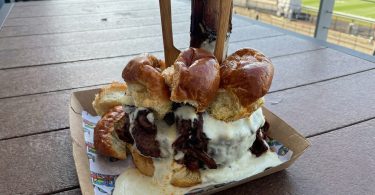 Veliki burger sa mesom, sausom i pršutom na bijeli tanjur