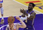 Košarkaš u Lakers uniformi drži košarkašku loptu tijekom utakmice