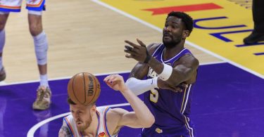 Košarkaš u Lakers uniformi drži košarkašku loptu tijekom utakmice