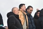 Muškarac u žutoj jakni i crnoj jakni na tribinama stadiona