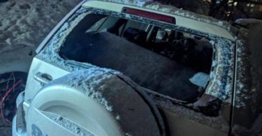 Oštećeno bijelo vozilo s razbijenim prozorima nakon noćnog napada dronovima u Kijevu