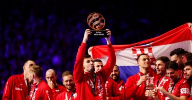 Rukometna reprezentacija s trofejom, zastavom Hrvatske i medaljama, igrači u crvenim dresovima