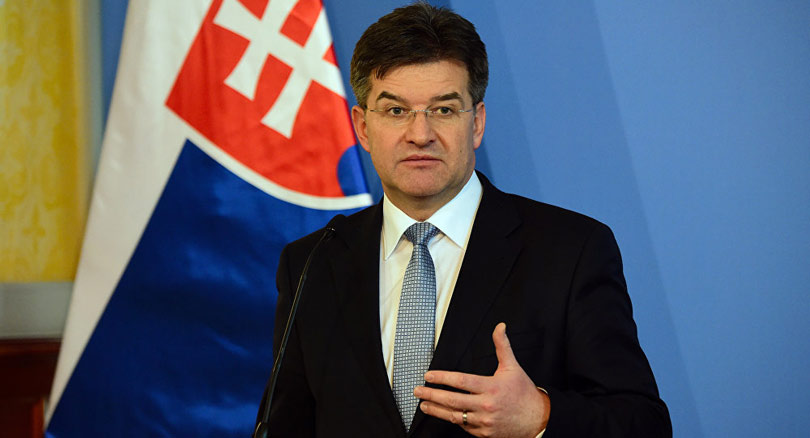 Miroslav Lajčak, muškarac u odijelu i kravati, govori pred zastavom, portretna fotografija