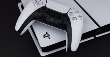 Bijeli PlayStation 5 kontroler DualSense pored PS5 konzole na crnoj površini