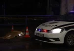 Policijski automobil s uključenim svjetlima noću pored mjesta događaja