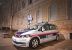 Возило австријске полиције припаркано испред стамбене зграде ноћу