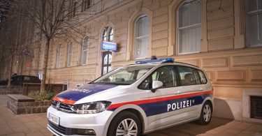 Возило австријске полиције припаркано испред стамбене зграде ноћу