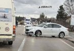 Bijeli automobil oštećen u sudaru na cesti, vozila i očevid na mjestu nesreće