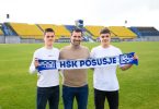 Tri osobe s šalskom HŠK Posušje na stadionu tijekom potpisivanja profesionalnih ugovora