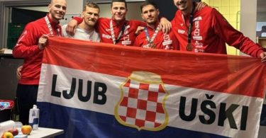 Grupa hrvatskih rukometaša u crvenim dresovima s hrvatskom zastavom Ljubuski