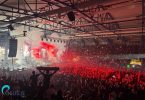 Masovna publika sa crvenim svjetlosnim efektima tokom rock koncerta u velikoj dvorani