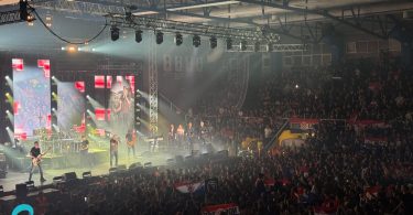Veliki koncertni događaj s puno publike, svetlosni efekti i pozornica s izvođačima