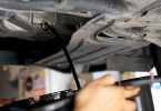Mehaničar provjerava boju dizelskog ulja šipkom za mjerenje u motoru