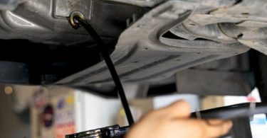 Mehaničar provjerava boju dizelskog ulja šipkom za mjerenje u motoru