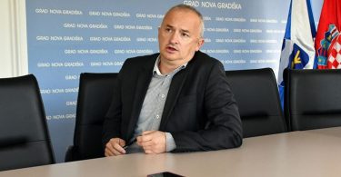 Muž u poslovnom odijelu za stolom tijekom saslušanja
