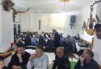 Publika sluša nastup tradicijske glazbe u dvorani, guslarci i glazbenici izvode na pozornici